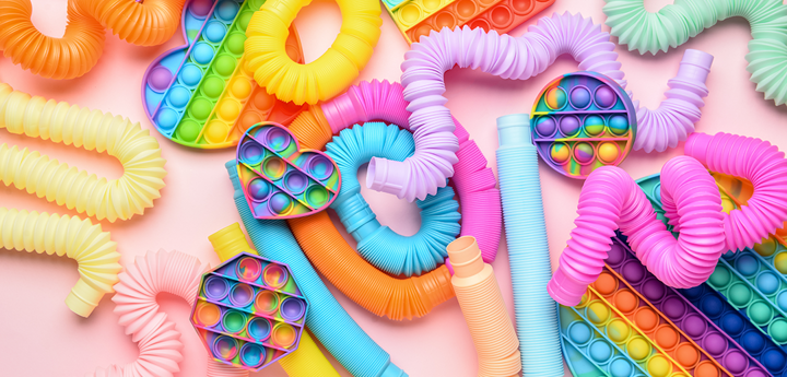Variety of plastic fidget toys including plastic snakes and popper fidget toys.