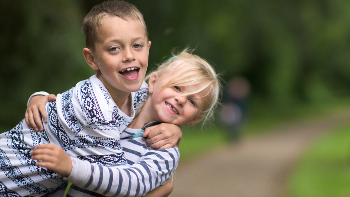 2 children hugging outdoors