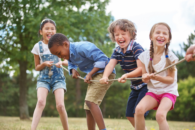 children laughing and playing tug of war