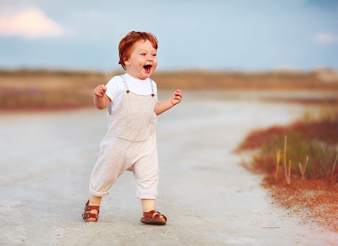 Toddler happily walking outside