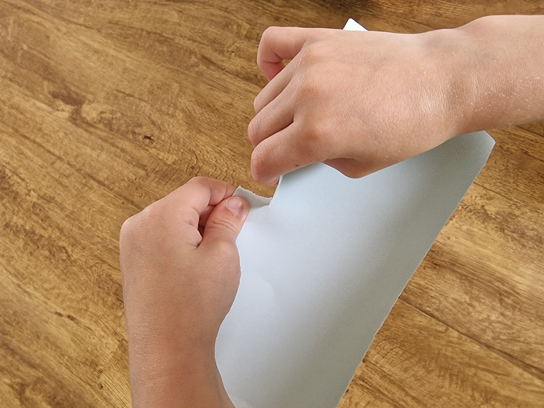 child tearing paper