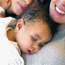 Baby sleeping face down on woman's chest.