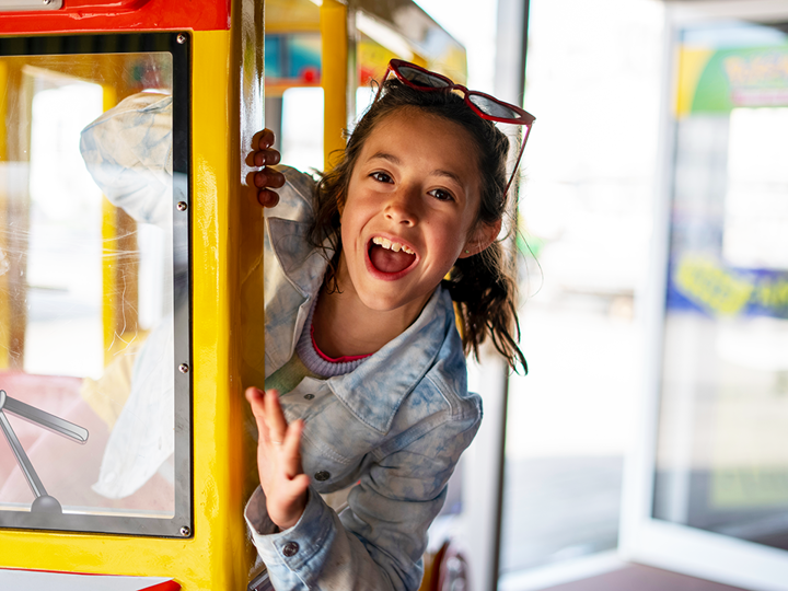 Excited girl in supermarket ride.