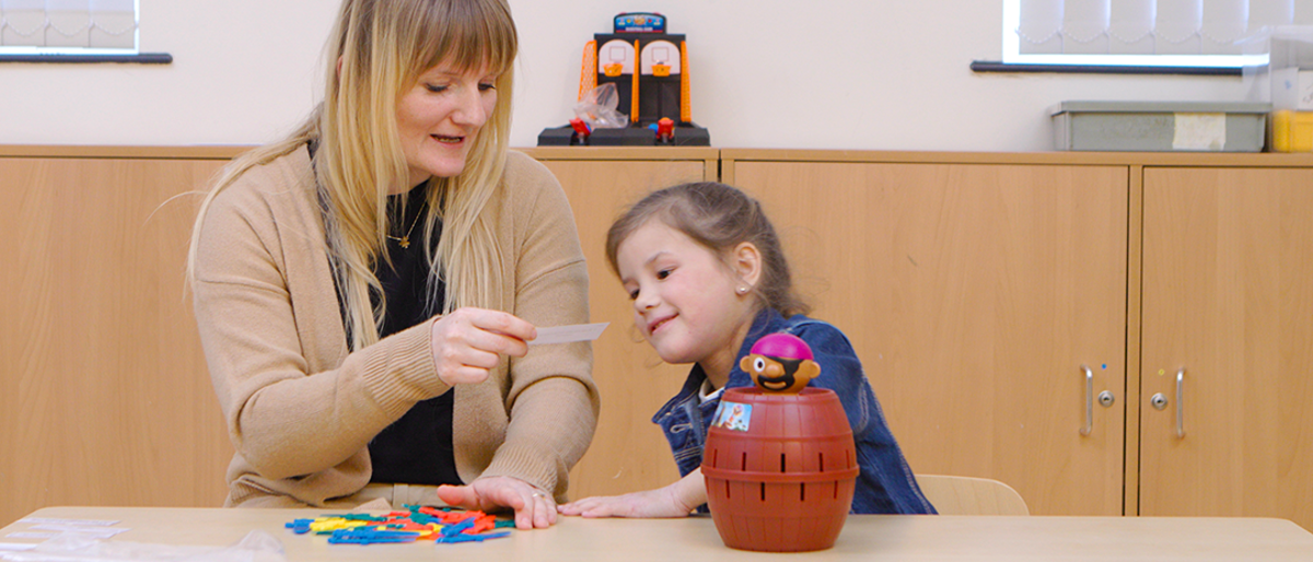 Adult and child looking at a piece of paper whilst playing pop-up pirate