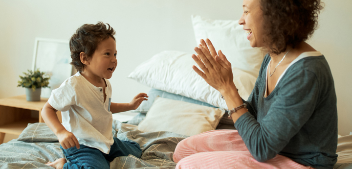 Mum And Son Both Sitting On A Bed