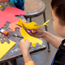 Boy cutting yellow paper using scissors