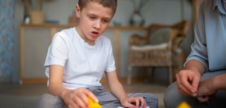 Mum Playing With Her Son On The Floor With Toy Blocks