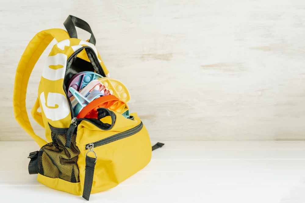 yellow backpack filled with fidget toys like silicon popping toys