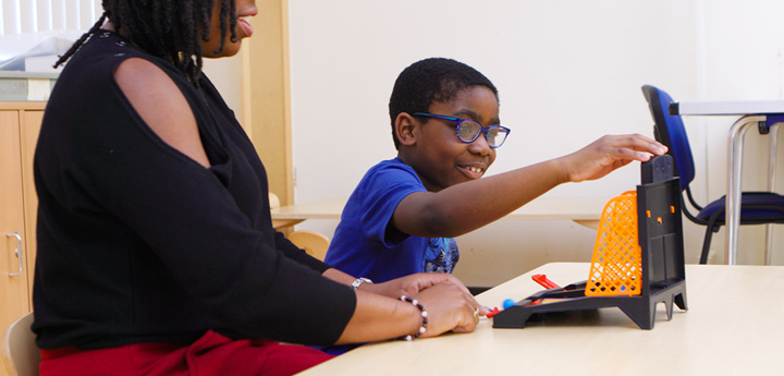 Adult and child playing connect 4 at a table