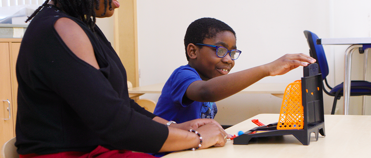 Adult and child playing connect 4 at a table