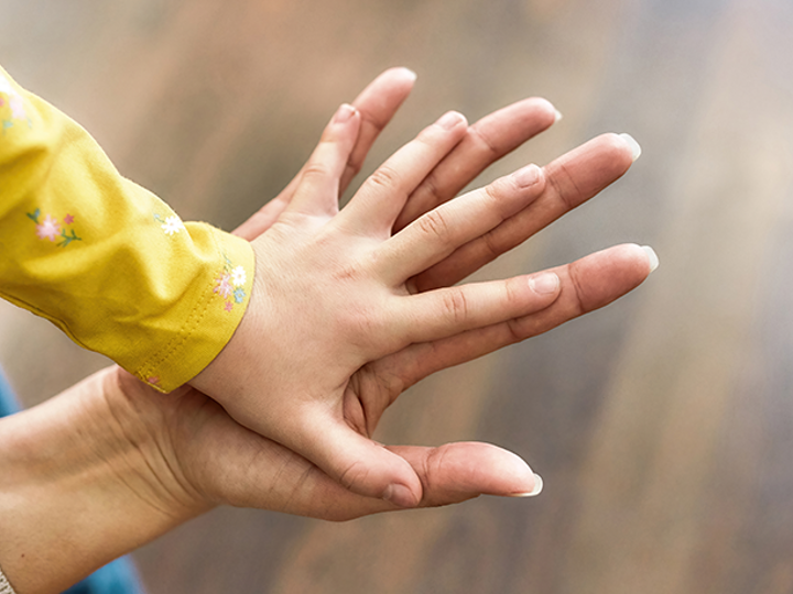 Child's hand placed down on top of an adults hand.