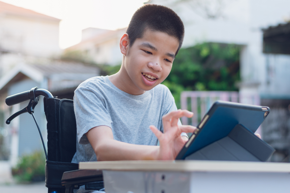 Disabled young a using a tablet on outdoor table