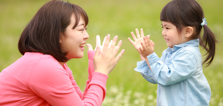 Child and adult outside clapping.