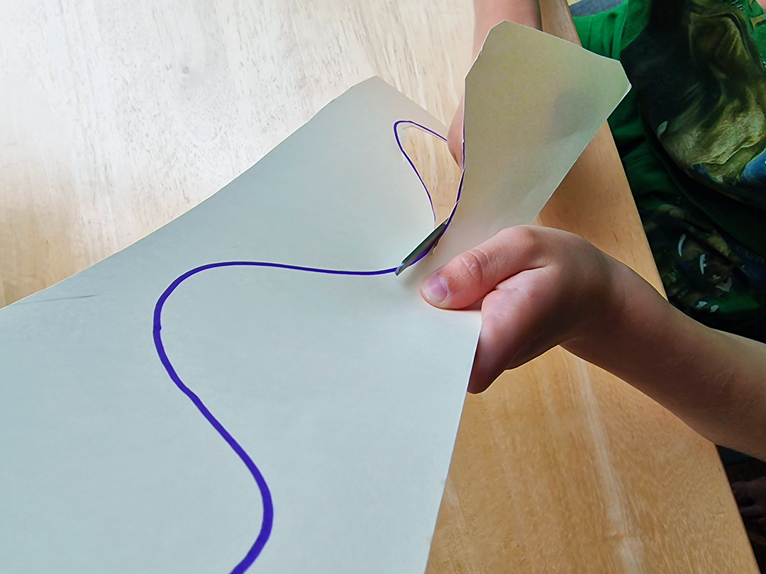 Child cutting a curved line with scissors