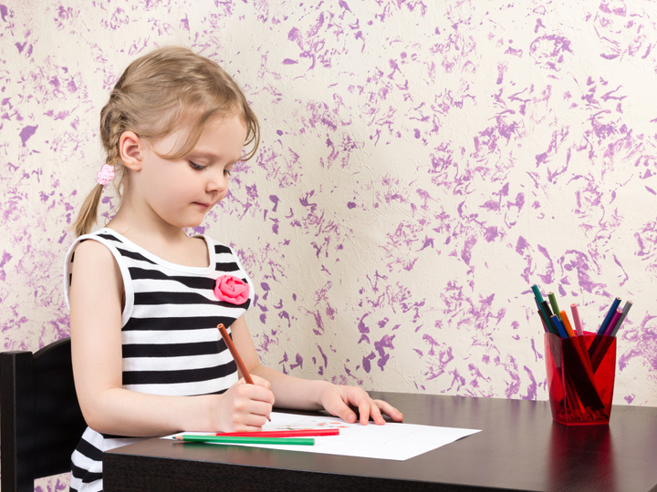 Child sitting at a table drawing