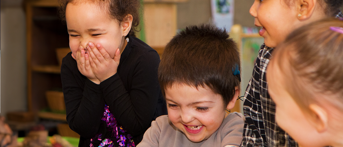 Four children laughing and smiling together.