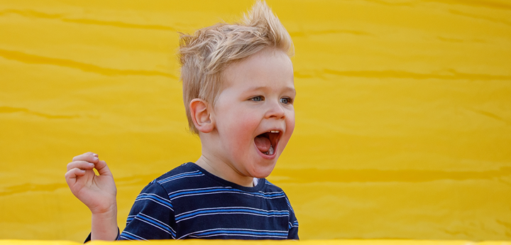 Child screaming happily on a an inflatable slide.