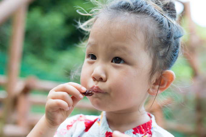 girl eating a raisin