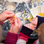 Showing only their hands. Adult and child playing with food. The background is a messy table covered with flour and pasta