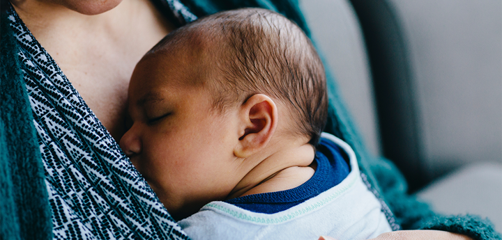 Newborn baby sleeping on mother's chest.