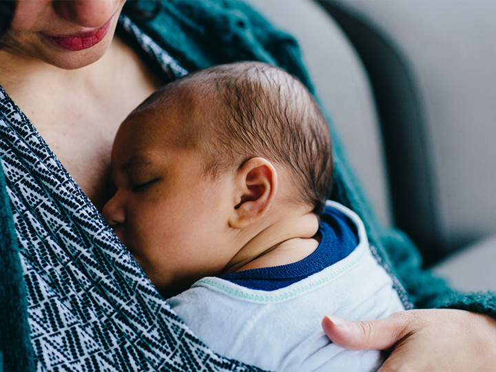 Newborn baby sleeping on mother's chest.