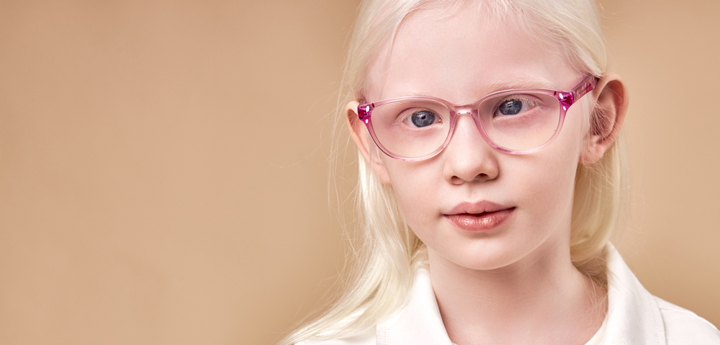 Girl with albinism wearing pink glasses.