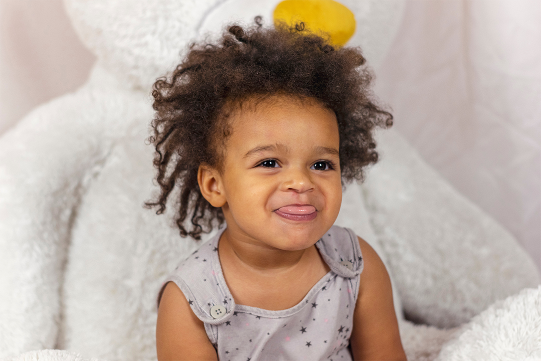 Young child sticking their tongue out with a cheeky smile