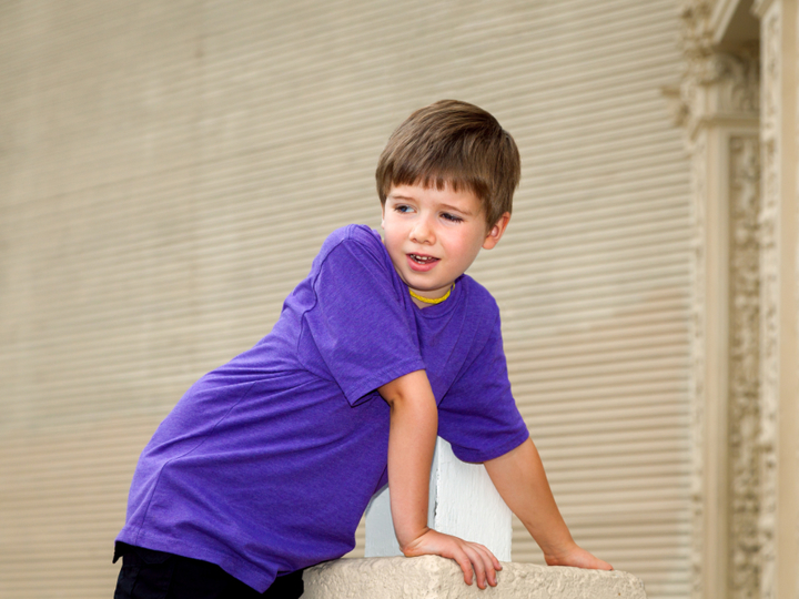 boy with hypermobility leaning on plinthe and over-extending his elbow