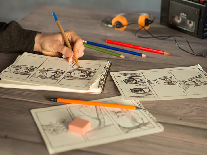 A child drawing comic characters at a table